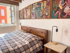 um quarto com uma cama e pinturas na parede em Art apartment Alla casa del Gastaldo em Gorizia