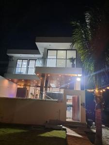 ein Haus mit einer Palme in der Nacht davor in der Unterkunft Hermosa casa frentes al mar en Montanita con piscina in Montañita