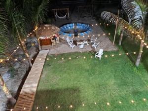 um quintal com uma mesa, cadeiras e luzes em Hermosa casa frentes al mar en Montanita con piscina em Montañita
