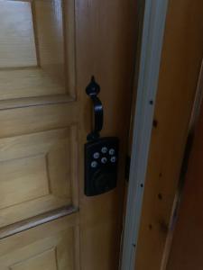 Un bussatore di porta nera è appeso ad una porta di Havre chez Guylaine a Laval