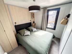 ein Schlafzimmer mit einem Bett mit zwei Kissen darauf in der Unterkunft Chalet standing, 6 couchages, piscine chauffée, terrasse privée, proche plage et commerces - FR-1-361-520 in Jullouville-les-Pins + 11 Fotos