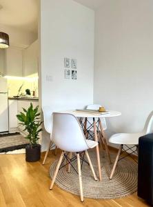 einen weißen Tisch und Stühle im Wohnzimmer in der Unterkunft Urban 3 - Apartment for modern nomads in Skopje