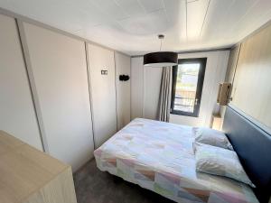 une petite chambre avec un lit et une fenêtre dans l'établissement Chalet à Jullouville - 6 couchages, piscine chauffée, près de la plage et commerces - FR-1-361-523, à Jullouville 14 autres photos
