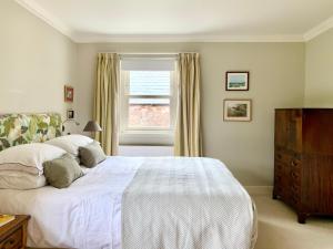 a bedroom with a white bed and a window at Coullie Stays in Auchenblae