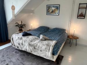 een slaapkamer met een bed met een bank erop bij Guesthouse BedNboot met terras aan het water in Rijpwetering