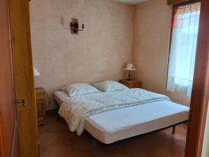 a bedroom with a bed with white sheets and a window at Appartement Corrençon-en-Vercors, 3 pièces, 7 personnes - FR-1-761-7 in Corrençon-en-Vercors