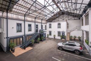 un'auto parcheggiata in un parcheggio in un edificio di Le Nouvel Hôtel a Oyonnax