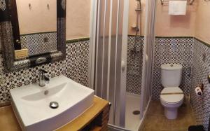 a bathroom with a sink and a shower and a toilet at Hostal Rural Marques de Zahara in Zahara de la Sierra