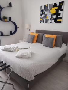 una camera da letto con un grande letto con cuscini arancioni e grigi di Casa dei nonni a Capurso