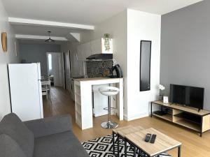 ein Wohnzimmer mit Couch und Tisch und eine Küche in der Unterkunft ღ Hubble • Au cœur de Saintes, Spacieux & Wifi in Saintes