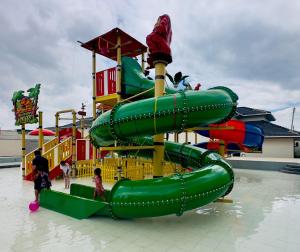 a green slide at a water park with children on it at Ivory Park Hotel - Safari Waterworld in Nakuru