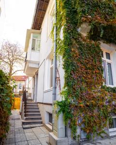 un edificio cubierto de hiedra con escaleras y un edificio en Mansarda Cotroceni, en Bucarest