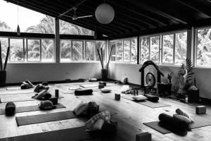 een kamer met mensen die yoga doen in een kamer met ramen bij Sattva Land in Belmopan