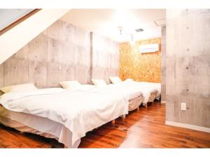 a row of white beds in a room at ONE Hostel Himeji - Vacation STAY 98707v in Himeji