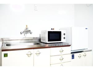 a kitchen with a sink and a microwave at ONE Hostel Himeji - Vacation STAY 98707v in Himeji