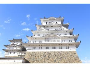 a tall white building with a blue sky in the background at ONE Hostel Himeji - Vacation STAY 98707v in Himeji