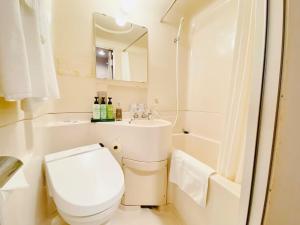een witte badkamer met een toilet en een wastafel bij Hotel 1-2-3 Maebashi Mercury - Vacation STAY 01042v in Maebashi