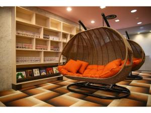 a hanging chair with orange pillows in a store at Hotel 1-2-3 Maebashi Mercury - Vacation STAY 01042v in Maebashi