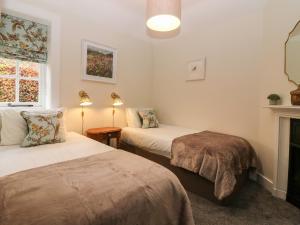 a room with two beds and a fireplace at West Cottage - Tarvit in Cupar