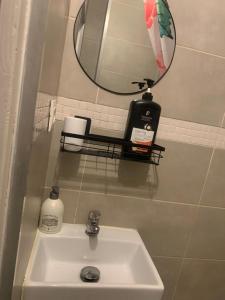 a bathroom sink with a mirror and a soap dispenser at Paris Jolie studio cosy in Paris