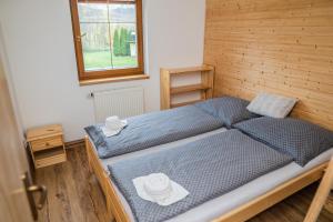 1 dormitorio con 2 camas con sábanas azules y ventana en Vilka Viktorka en Velké Losiny
