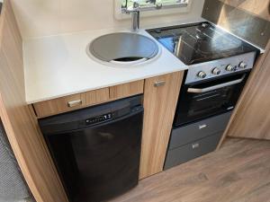 a small kitchen with a sink and a dishwasher at Swift Escape 664 - 4 Berth Motorhome in Kirton