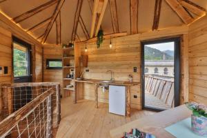 a kitchen in a wooden cabin with a large window at ESCALE CAB'ÂNE in Mittlach