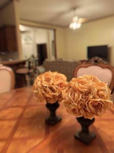 twee bloemen in vazen op een houten tafel bij Spacious Oasis - 4 BDRM Top Luxury Home in Edmond! in Edmond