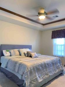 een slaapkamer met een bed en een plafondventilator bij Spacious Oasis - 4 BDRM Top Luxury Home in Edmond! in Edmond