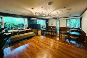 a living room with a couch and tables and chairs at Windy Hill Morinoyado - Vacation STAY 07709v in Yamanakako