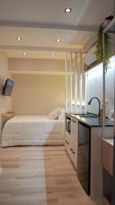 Cet appartement comprend une chambre avec un lit et une cuisine avec un comptoir. dans l'établissement Apê Pátio Paulista, à São Paulo