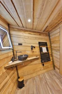 a bathroom with a sink in a wooden cabin at ESCALE CAB'ÂNE in Mittlach