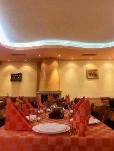 une salle à manger avec une table et un tissu de table rouge dans l'établissement Daf Trans Hotel, à Pechtera