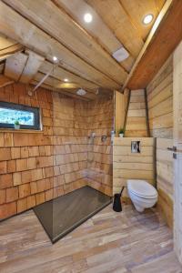 La salle de bains en bois est pourvue de toilettes et d'une douche. dans l'établissement ESCALE CAB'ÂNE, à Mittlach