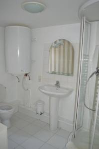 ein weißes Badezimmer mit Waschbecken und Toilette in der Unterkunft Maison de gardien chauffée au bois avec petit déj in Charolles