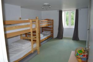zwei Etagenbetten in einem Zimmer mit Fenster in der Unterkunft Maison de gardien chauffée au bois avec petit déj in Charolles