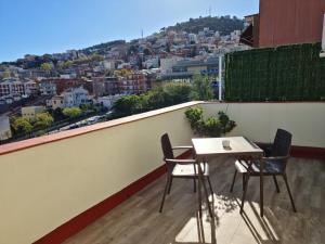 a table and chairs on a balcony with a view at Ático con vistas panoramicas in Barcelona