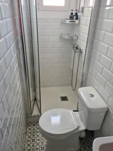 a white bathroom with a shower and a toilet at Ático con vistas panoramicas in Barcelona