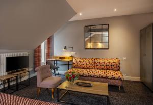 a living room with a couch and a table at Le Nouvel Hôtel in Oyonnax
