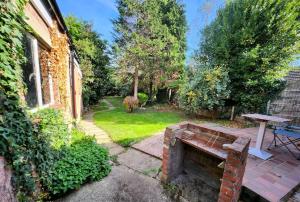 een tuin met een stenen bank naast een huis bij Lovely Spacious Stays in Cambridge