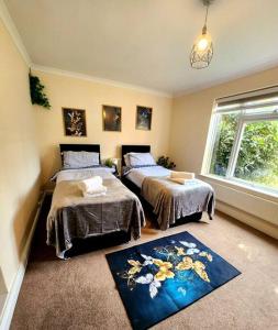 een slaapkamer met 2 bedden en een raam bij Lovely Spacious Stays in Cambridge