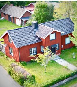 une maison rouge avec un toit noir dans l'établissement Lilla Röda Huset., à Sjötofta