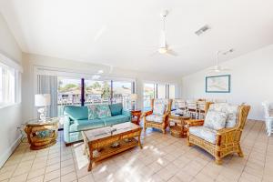 een woonkamer met een bank, stoelen en een tafel bij Sea Pointe & Canal-side Charisma in Key Colony Beach