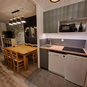 une cuisine avec une table en bois et une salle à manger dans l'établissement APPARTEMENT 310 ECRIN D'HUEZ, à L'Alpe-d'Huez