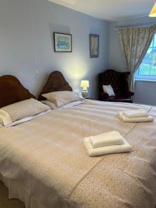 a large bed with two towels on top of it at Lucy Cross Guest House in Lucy Cross