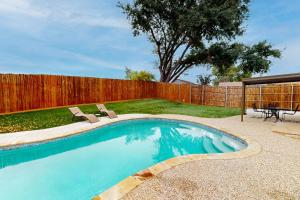 una piscina con 2 sillas y una valla en Warm Rays by Lewisville Lake, en The Colony