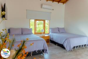 a bedroom with two beds and a window at El Encanto de las Aguas in Necoclí