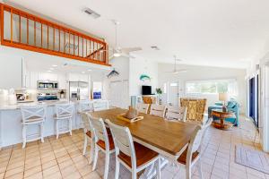 a kitchen and dining room with a wooden table and chairs at Sea Pointe on the Canal in Key Colony Beach