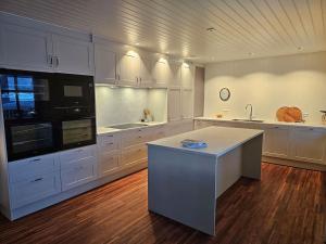 a large kitchen with white cabinets and a counter top at Villa Nestun - secluded oasis near Tromsø city in Selnes