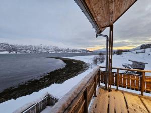 una casa con vistas al agua en la nieve en Villa Nestun - secluded oasis near Tromsø city, en Selnes